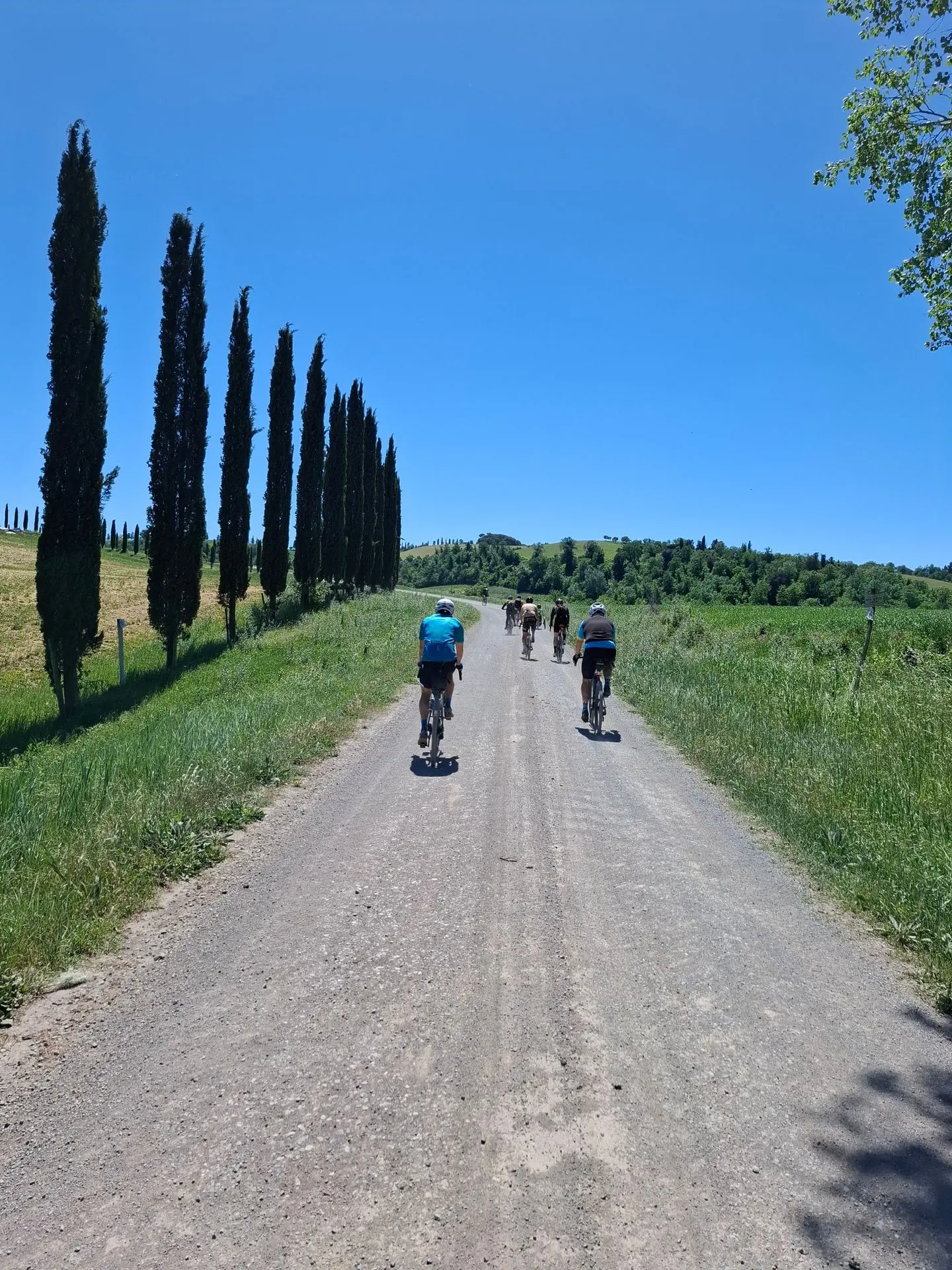 Groupe de cyclistes sur un chemin gravel en Toscane