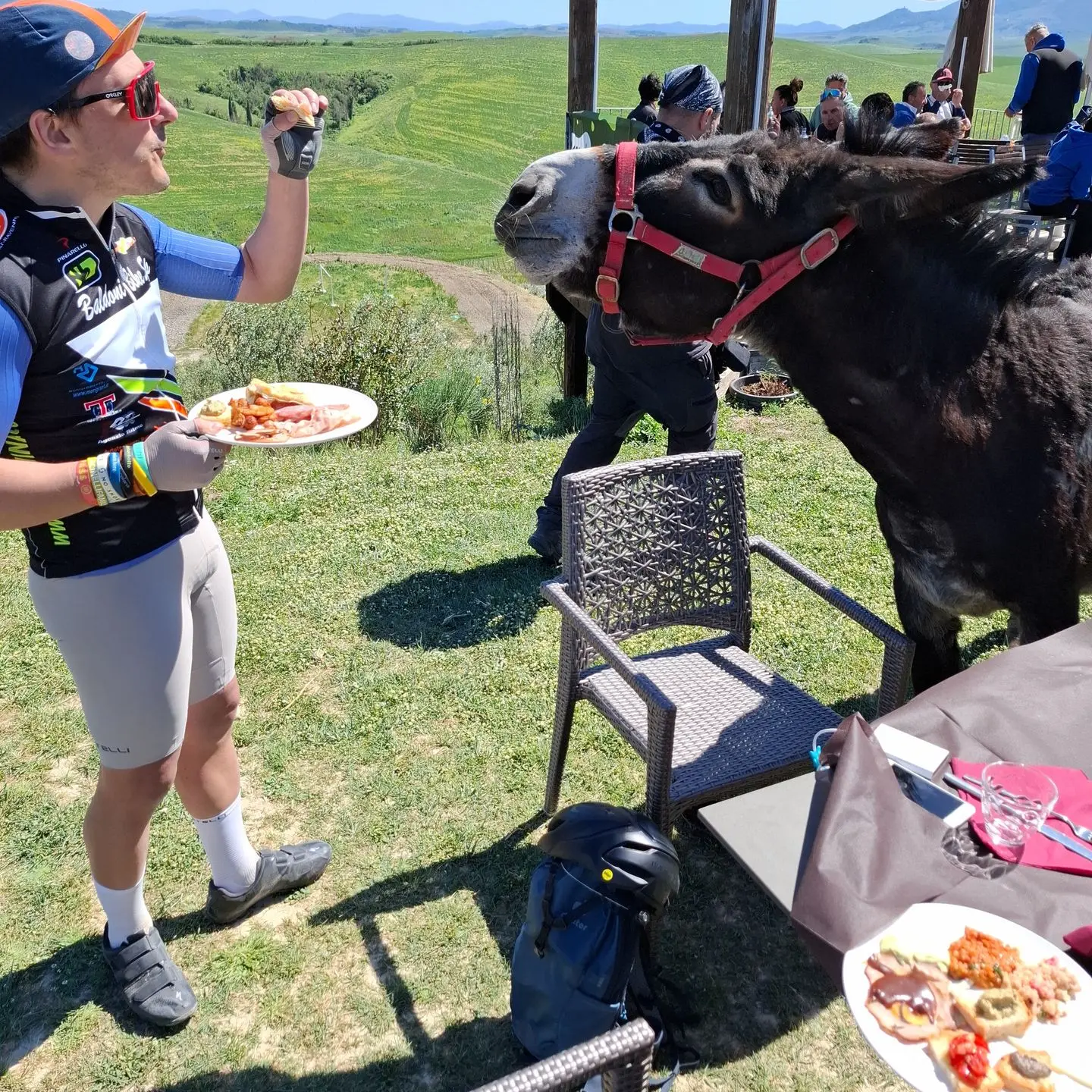 Pause déjeuner de cyclistes face aux collines toscanes
